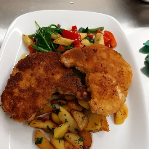 Paniertes Schnitzel mit Bratkartoffeln und Gemüse